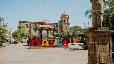 Letrero de Tequila en una plaza soleada de Jalisco con arquitectura histórica