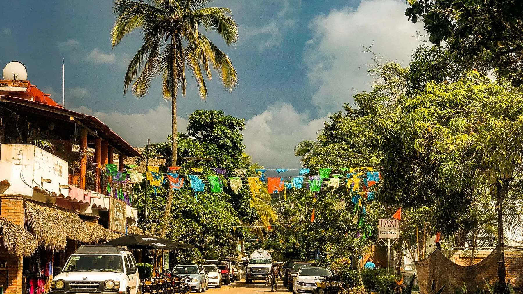 Calle de San Francisco, Nayarit, con banderas de colores colgadas sobre una palmera