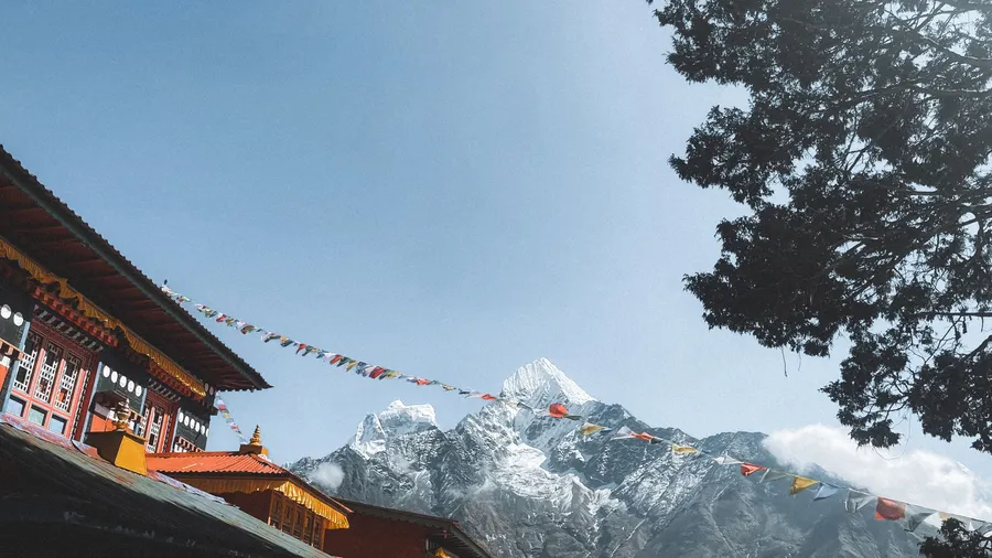 Monasterio budista en Nepal con montañas del Himalaya al fondo y cielo despejado